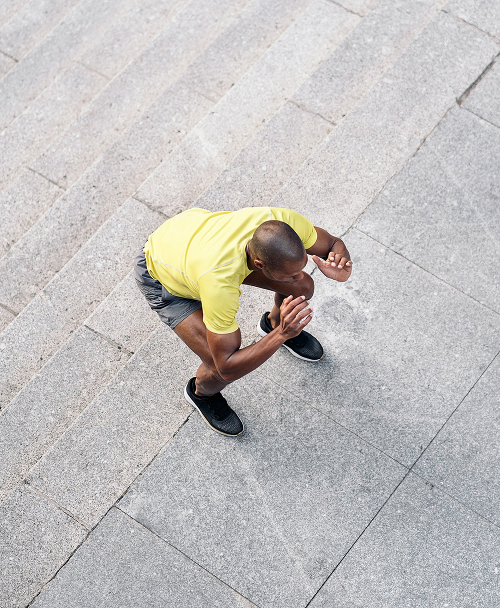 Aerial view of a man doing plyometrics jump squats up a staircase.