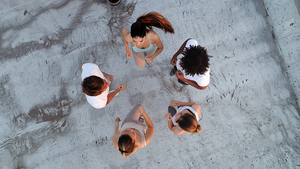 A group of friends formed around in a circle performing high knees