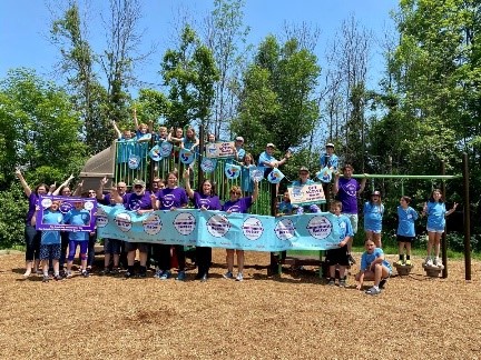 North Grenville residents holding up Community Challenge signs at a playground
