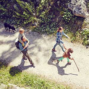 family of 4 walking on a path with a dog