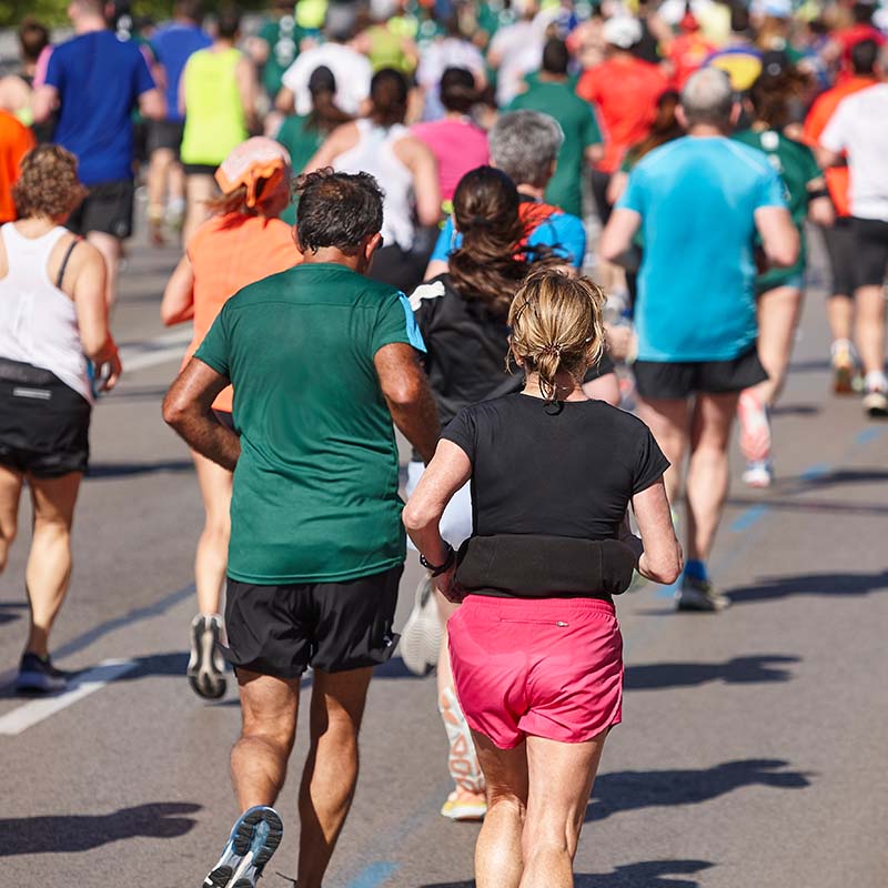 Un grand groupe de personnes court sur une route.  
