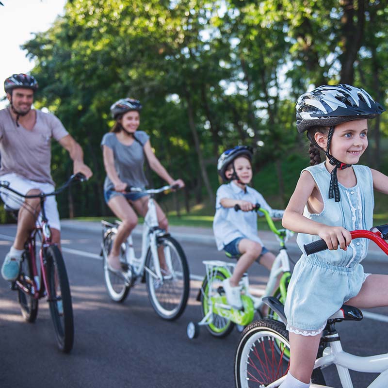 Une famille fait du vélo sur une route.