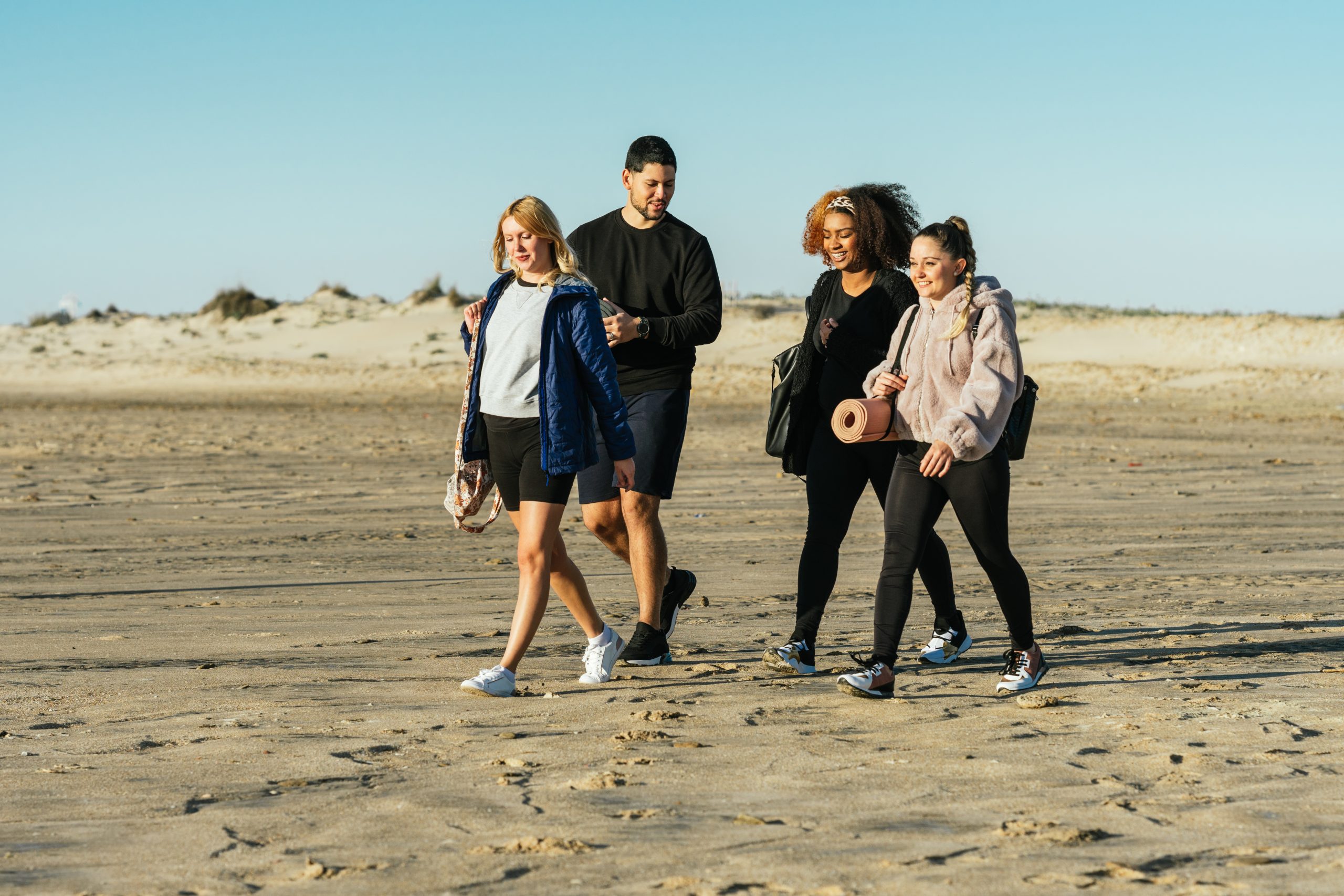A group of people walking on a beach.
