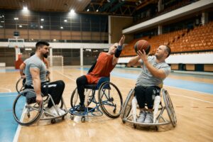 Un groupe d’hommes jouant au basketball en fauteuil roulant sur un terrain intérieur.