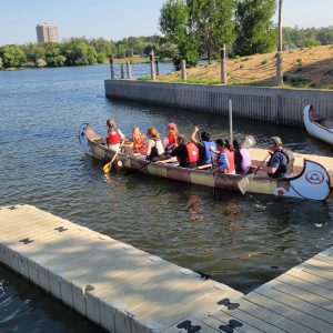 A group of people canoeing on a lake. A group of people canoeing on a lake.