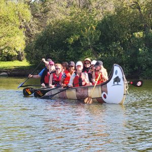 A group of people canoeing on a lake. A group of people canoeing on a lake.