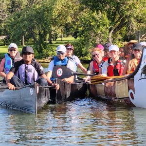 A group of people in canoes on a lake.