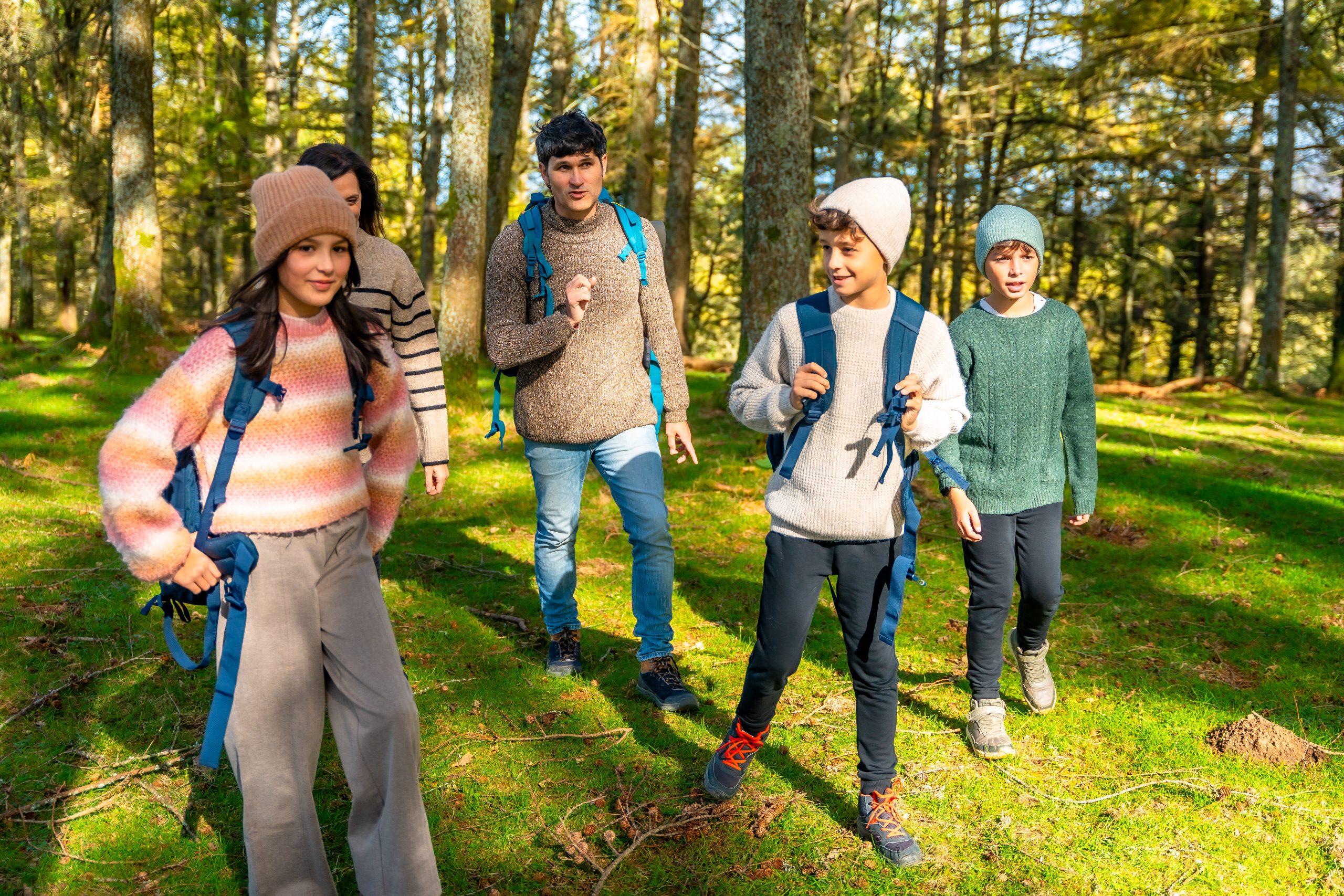 Three teenagers and their parents hiking in the woods. 