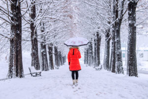 A woman walking on a snow-covered trail to skip the end-of-year burnout