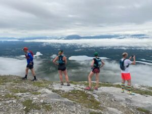 Group of people taking photos on top of a mountain