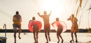 group of friends throwing themselves into the water