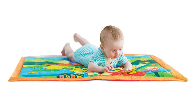 Happy little baby playing in his mat