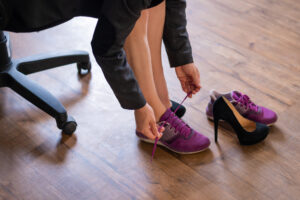 A woman putting sneakers on. 