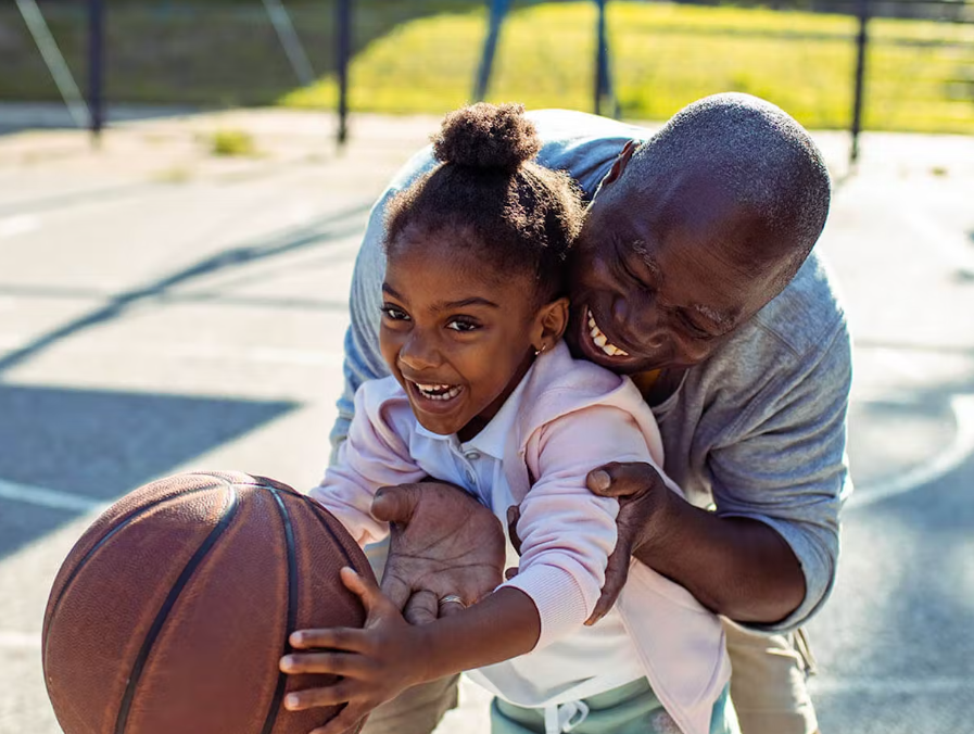 Father and little dautgher playing basketball