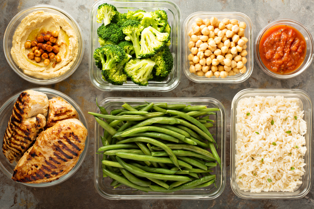 Du houmous, du brocoli, des pois chiches, de la salsa, du poulet grillé, des haricots verts et du riz sur une table. La préparation de repas Du houmous, du brocoli, des pois chiches, de la salsa, du poulet grillé, des haricots verts et du riz sur une table. La préparation de repas