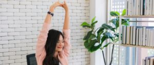 A woman stretching in her office during her workday.