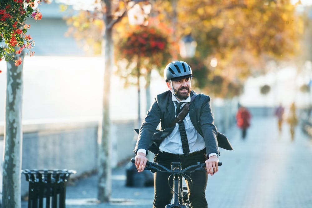 Young man cycling with a office suite