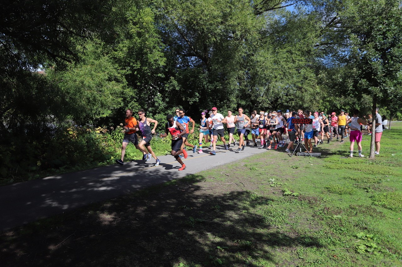 2022 National Capital Pride Run participants running on a park trail 2022 National Capital Pride Run participants running on a park trail