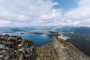 Un randonneur solitaire sur le sentier King's Throne surplombant le lac Kathleen dans le parc national Kluane.