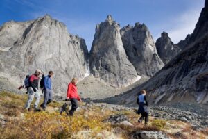 Four people hiking on a trail surrounded by mountains in the Yukon. 