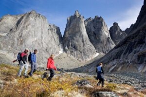 Quatre personnes en randonnée sur un sentier entouré de montagnes au Yukon