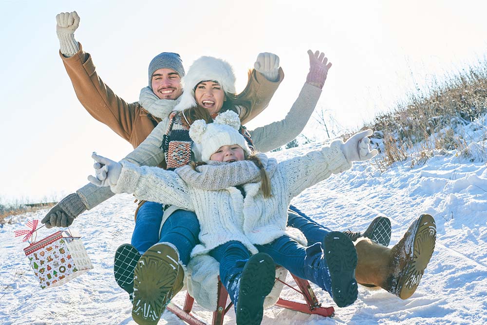 Une famille fait de la luge en décembre