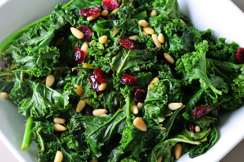 Une salade de chou frisé garnie de canneberges séchées et de graines. Une salade de chou frisé garnie de canneberges séchées et de graines.