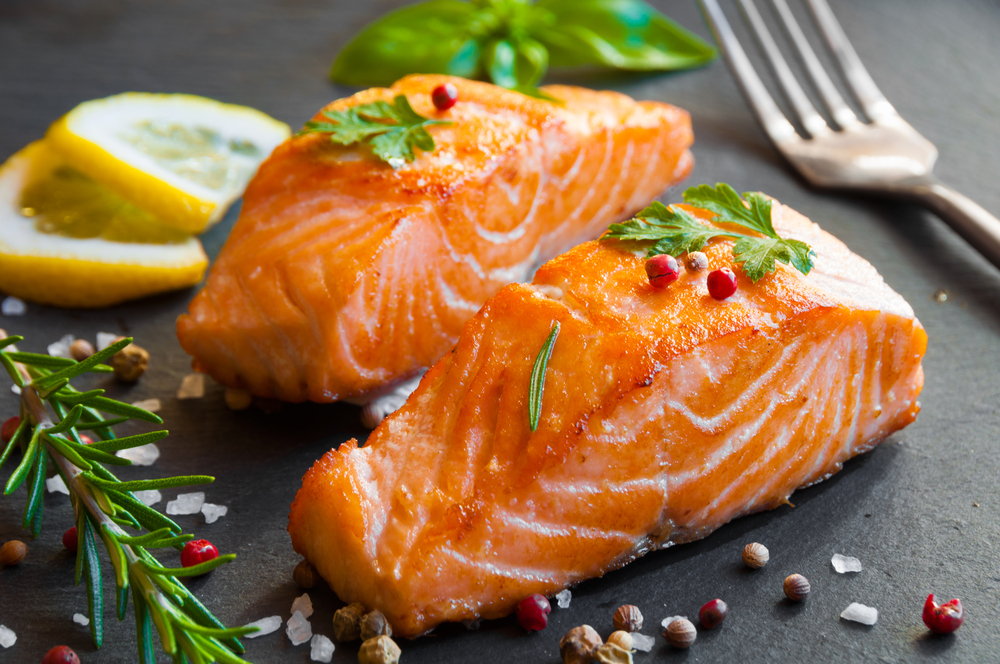 Delicious,Cooked,Salmon,Fish,Fillets Two filets of salmon and two lemon slices on a plate.