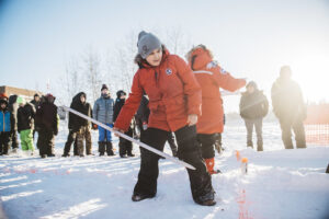 Un garçon s’adonne au jeu déné du serpent des neiges sur un terrain enneigé. 