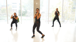 Three people air boxing in a workout studio. 