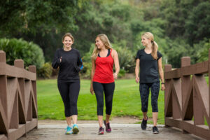 A group of women walking together on a park path. This activity is great for these women's health. 