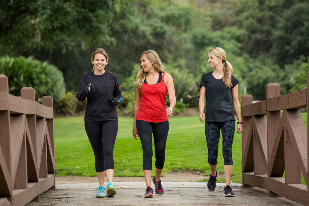 A group of women walking together on a park path. A group of women walking together on a park path.