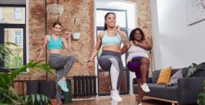 Un groupe de femmes exécutent des montées de genoux dans un salon.