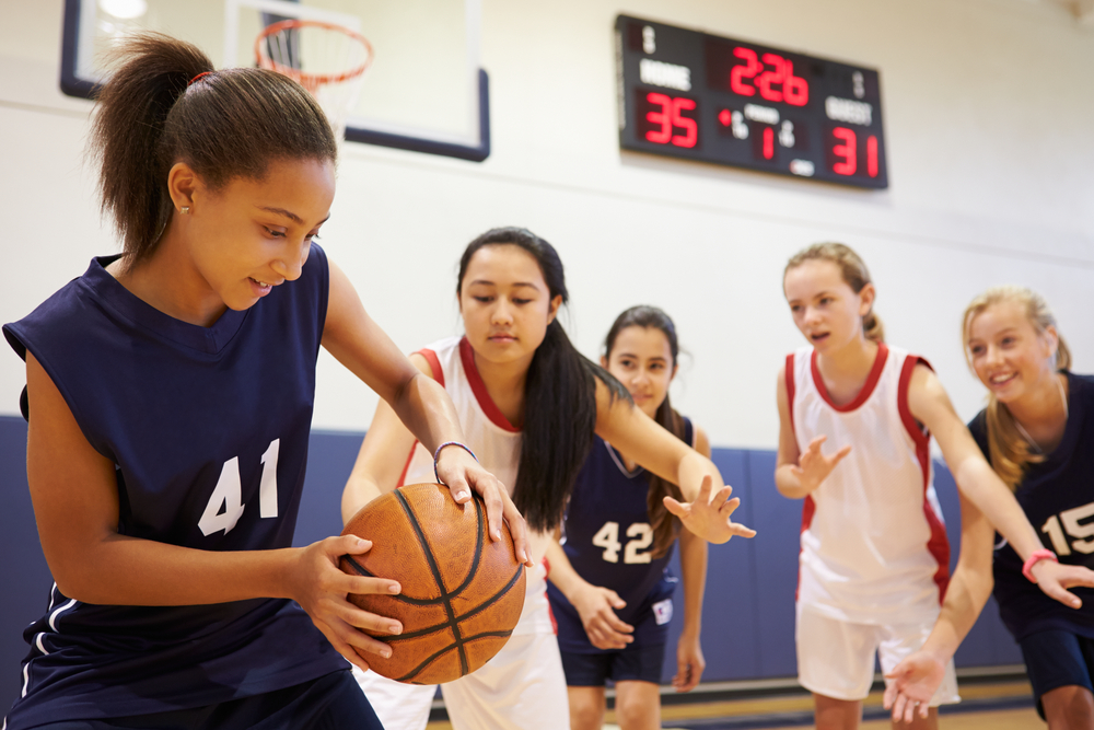 A group of teenage girls playing basketball. A group of teenage girls playing basketball.