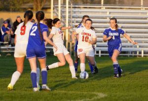 A group of teenage girls playing soccer. 