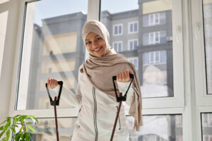 Une femme souriante s’entraînant avec des bandes de résistance.