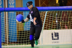 A man playing goalball, an accessible sport designed for people with visual impairments.