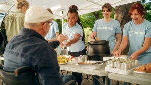 Un groupe de bénévoles d’une banque alimentaire sert de la nourriture et de l’eau à des personnes dans la communauté.