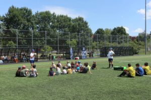 Un groupe d'enfants assis sur un terrain de rugby