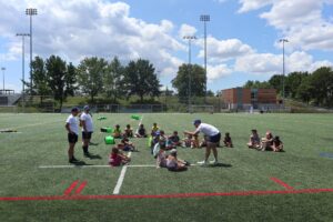 Un groupe d'enfants assis sur un terrain de rugby