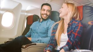 A man and woman sitting in a plane.  