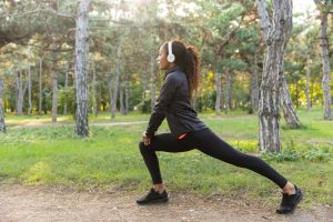 Une femme exécute une fente marchée dans un parc.