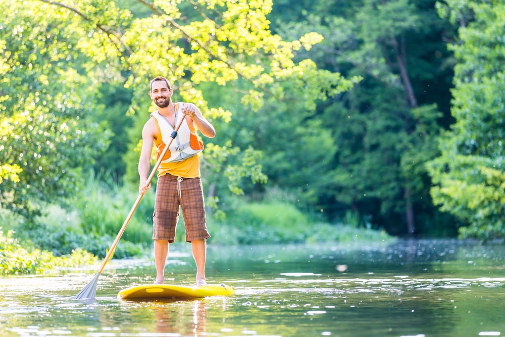 Un homme pagaie sur la rivière 