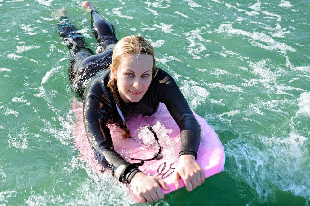 Une femme faisant du bodyboard sur l’océan. 