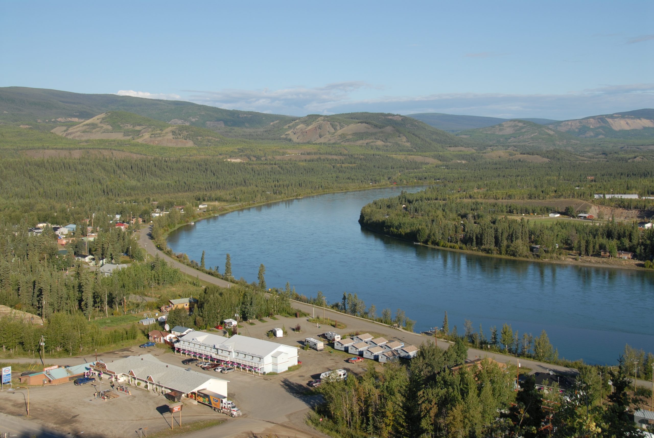 Une rivière entourée de maisons et de montagnes. 