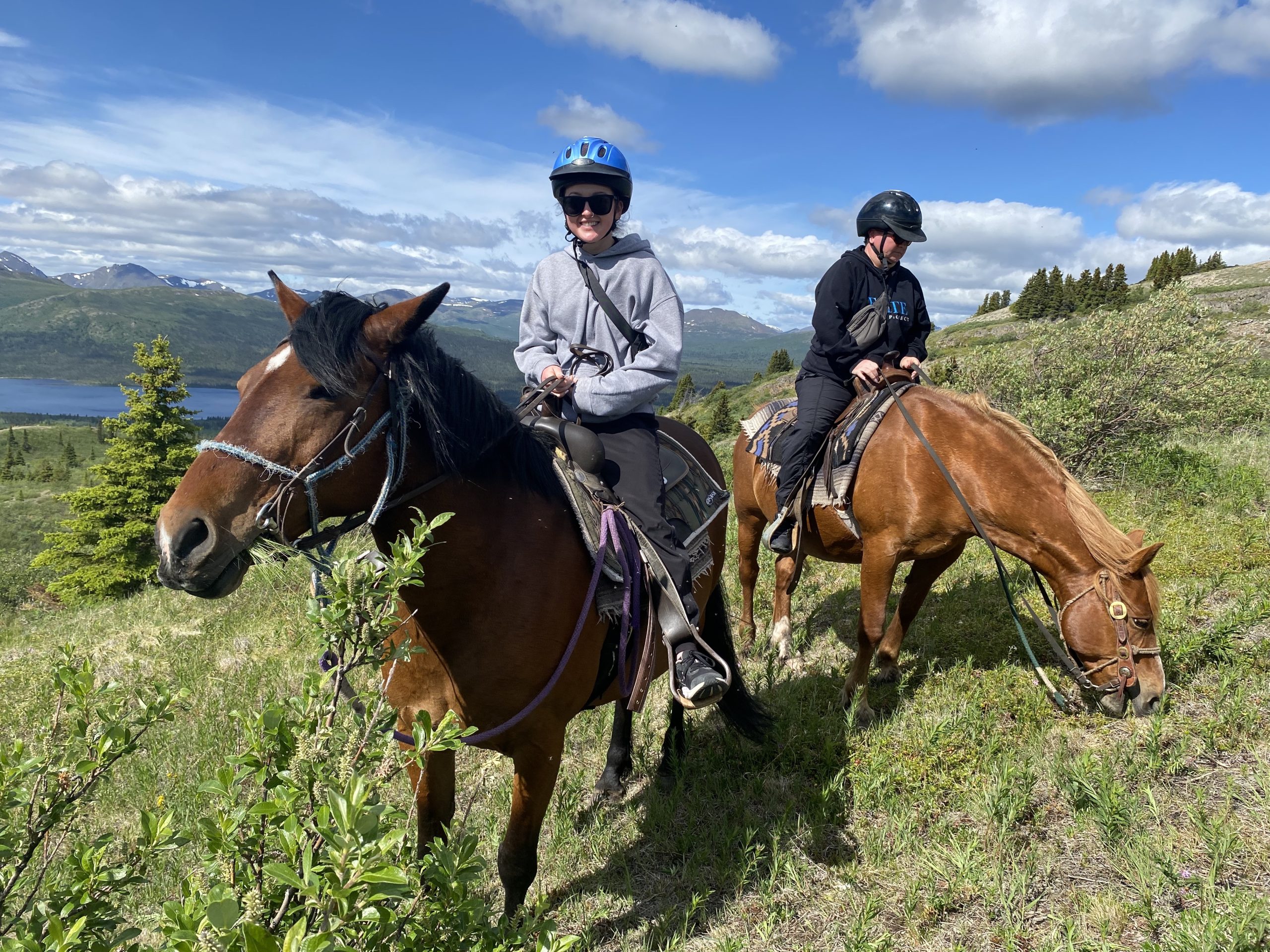 Madison et sa mère montées à cheval sur une colline.   