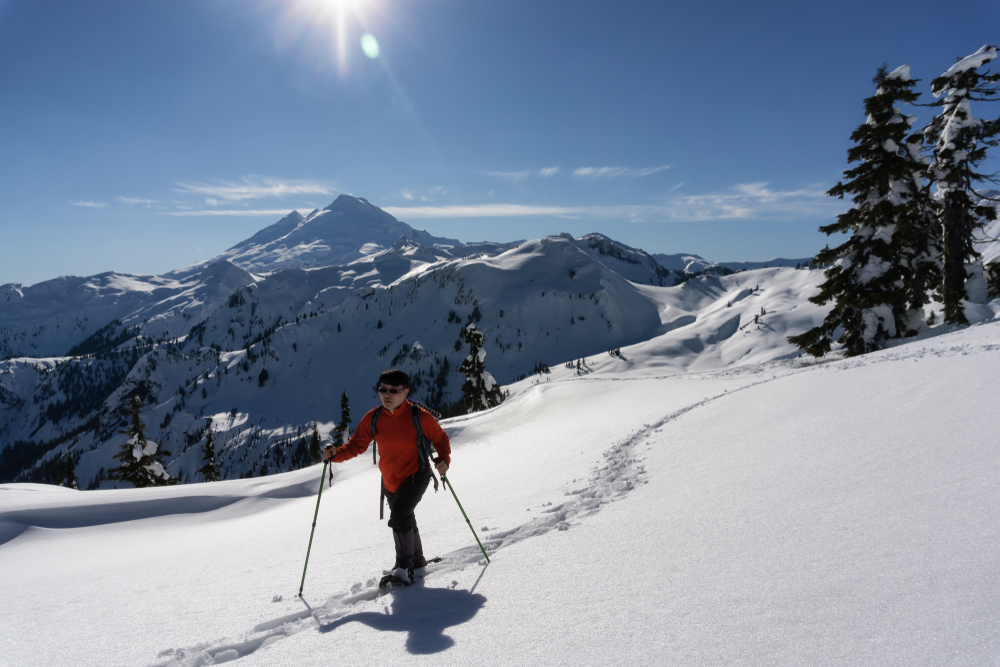 Un homme en raquettes sur une montagne.