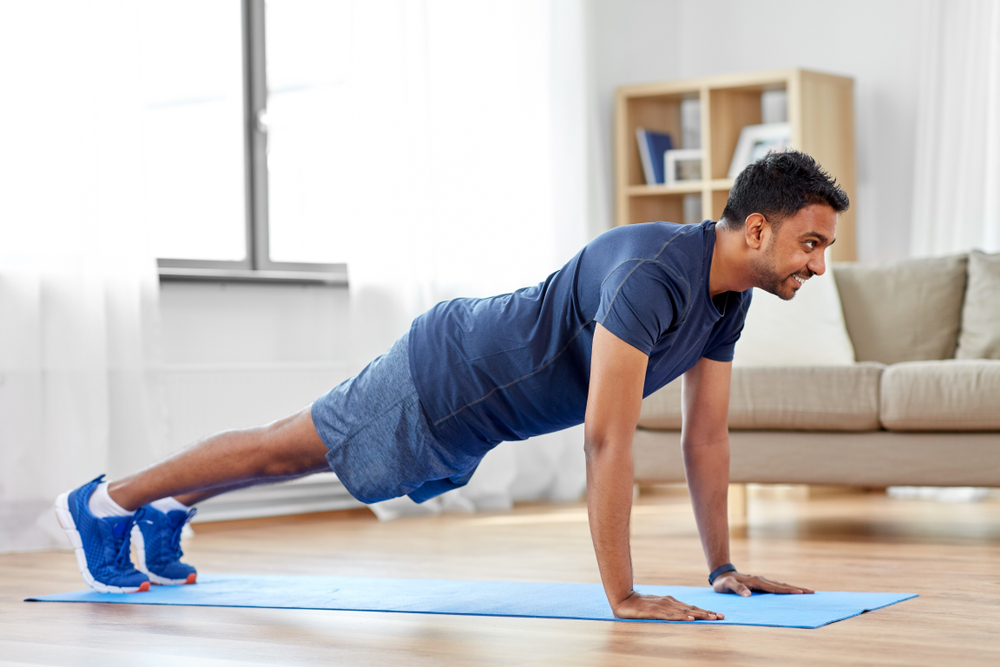 A man doing push-ups in a living room. 