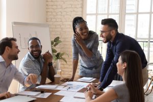 A group of office workers talking around a table.