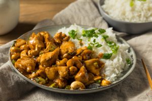 Une assiette garnie de poulet aux noix de cajou, de riz et d’oignons verts.